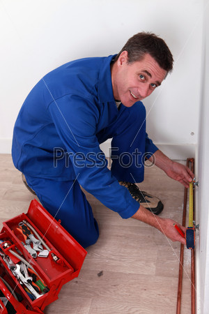 Man measuring copper tube