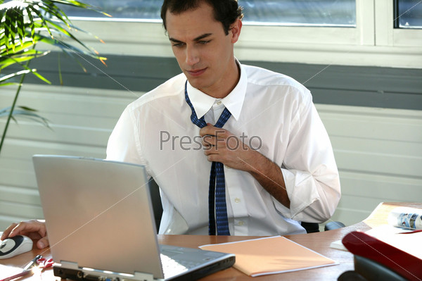 Stressed office worker loosening his tie