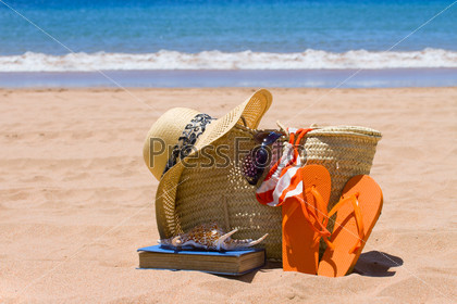 sunbathing accessories on sandy beach by the ocean