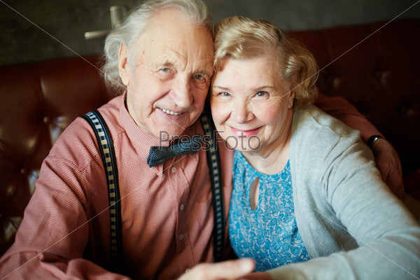 Portrait of retired couple in smart clothes looking at camera