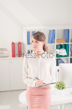 Vertical image of a business lady deeply contemplating while working at the office on the foreground