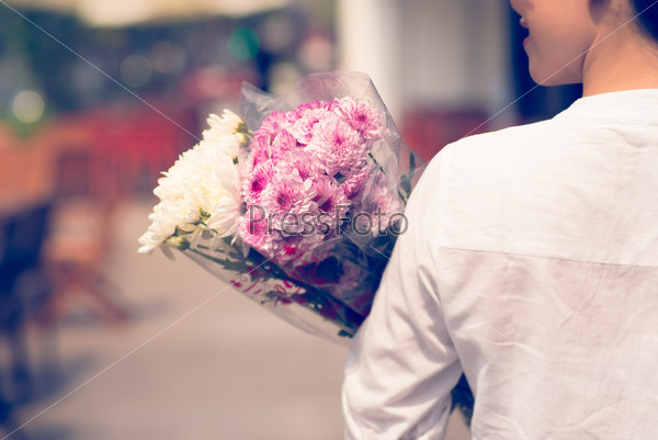 Back view of a woman holding adorable flower bouquets from the shop