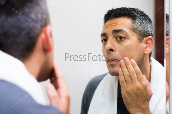 Close-up image of a man looking in the mirror before shaving in the morning