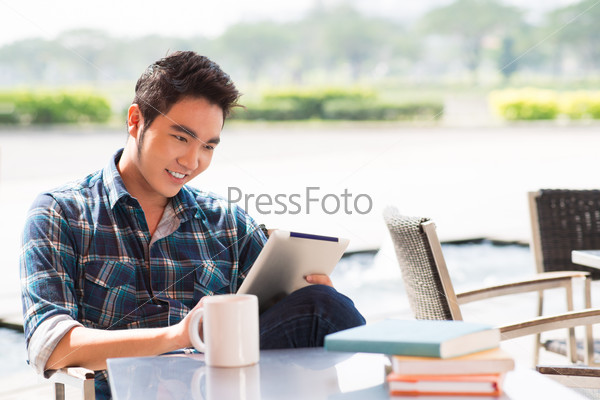 Copy-spaced image of a cheerful guy networking at a cafe