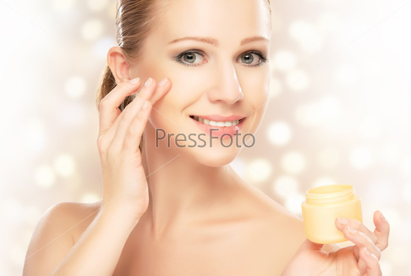 happy young beautiful woman using a face cream