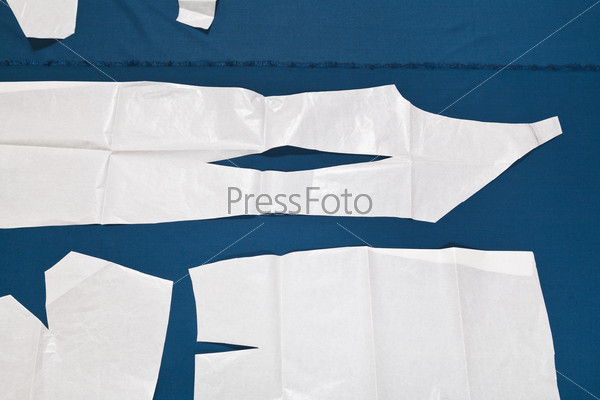 paper model of dress on blue fabric for dress cutting
