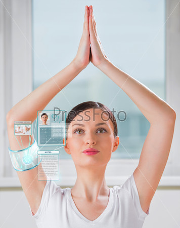 Woman doing exercise wearing smart wearable device with\
futuristic interface