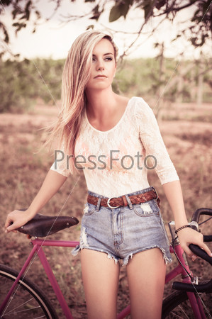 Young pretty blonde woman posing in summer sunshine
