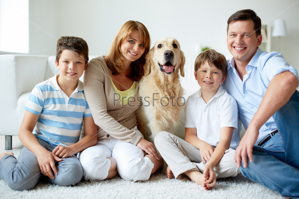 Portrait of happy family with their pet having rest at home