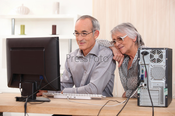 Elderly couple learning computer skills, stock photo