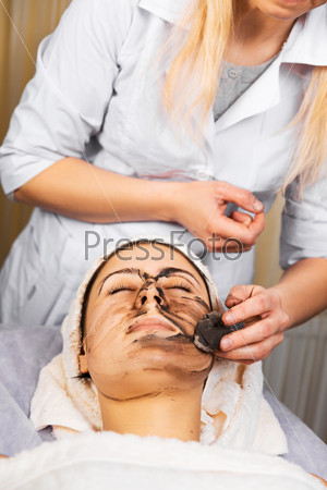 skin care, medical beautician removes the mask from the face of the girl