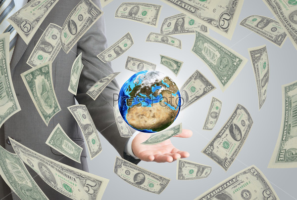 Businessman in a suit holding a earth. Money falling around. Elements of this image furnished by NASA