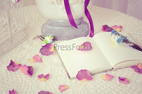 The book on a table with rose-petals
