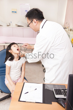 pediatrician examining  kid throat with  tongue depressor