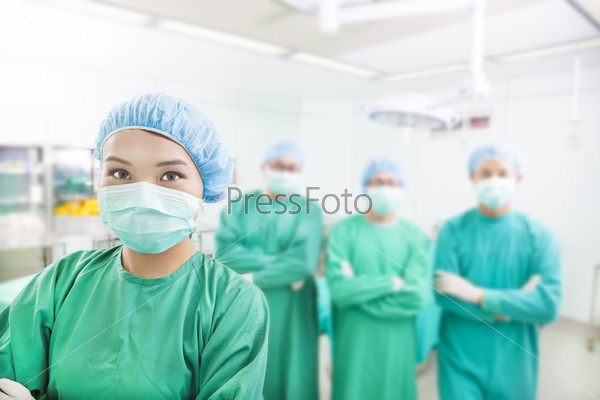 Smiling surgeon posing with aesthetic medicine teams