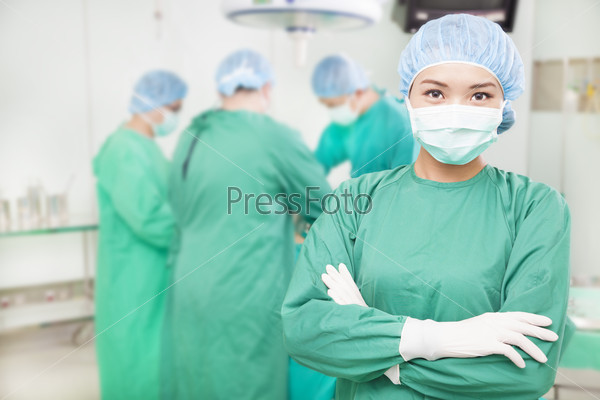 Confident female surgeons crossed hands with teams