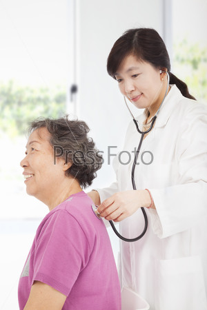home doctor measuring senior woman blood pressure