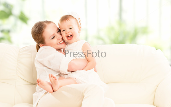 happy family. Mother and baby daughter plays at home on the sofa
