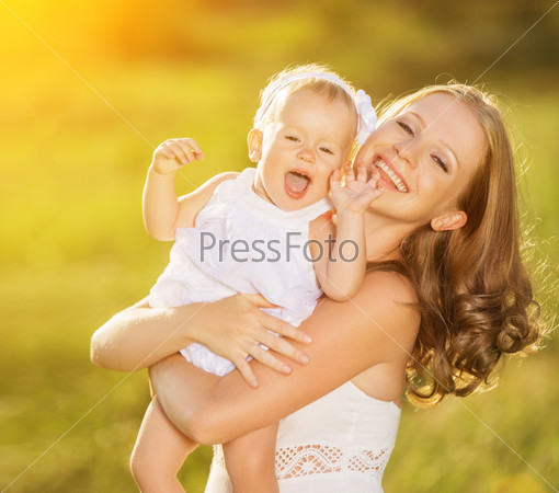 happy family on nature outdoors mother and baby daughter on the green meadow in a white dress