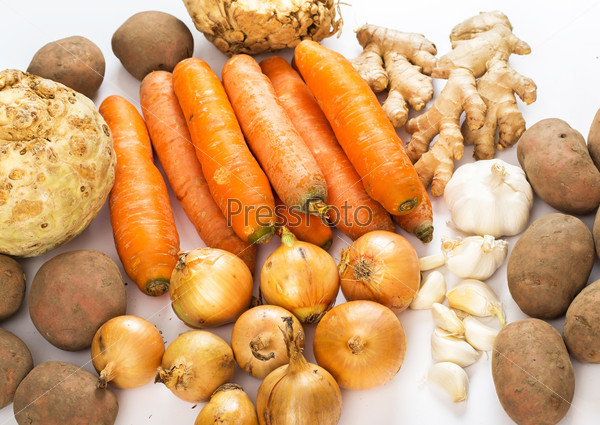 Garlic, carrots, potatoes, ginger and celery root on a white background
