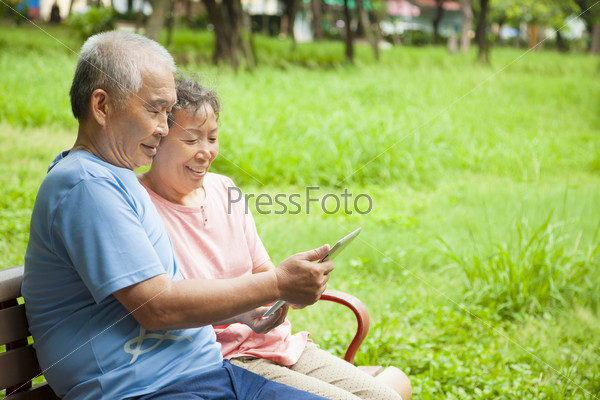 happy asian seniors couple with tablet pc
