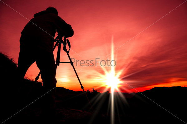 Silhouette of photographer on the top of mountain