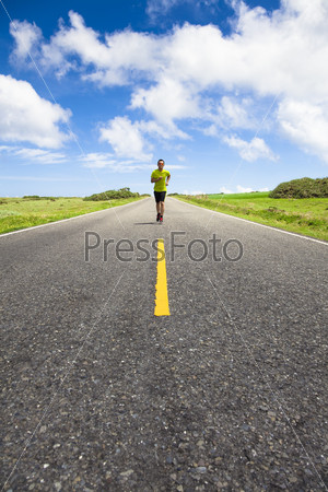 young man running on the empty road at summertime