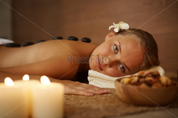 Portrait of young female looking at camera during spa procedure in beauty salon