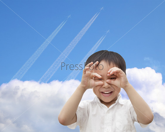 happy boy watching airplane flying through the sky over the cloud