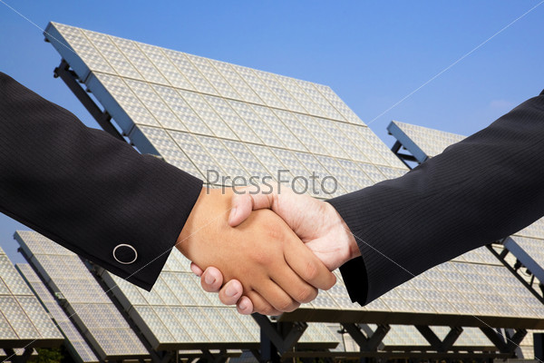 Деловое рукопожатие на фоне солнечной электростанции