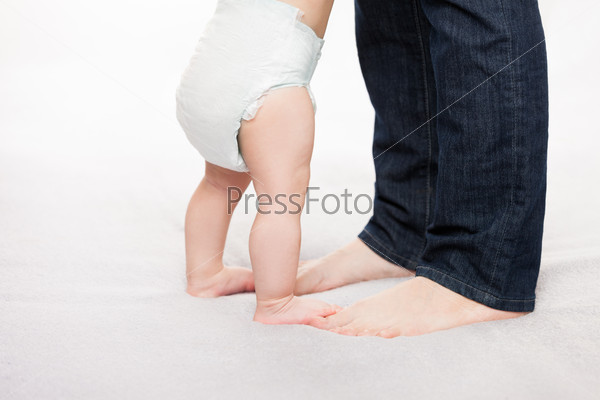 Mother holding little baby child boy making first step