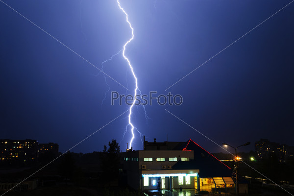 Severe lightning storm over a city buildings