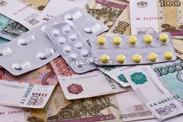 Medical pills on bank note as symbol for high costs