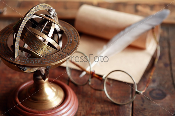 Vintage still life with Armillary sphere globe near quill and scroll