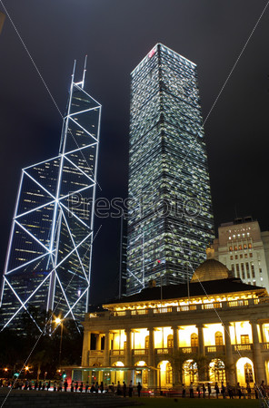 It is night scene of two skyscrapers behind a English building in Hong Kong