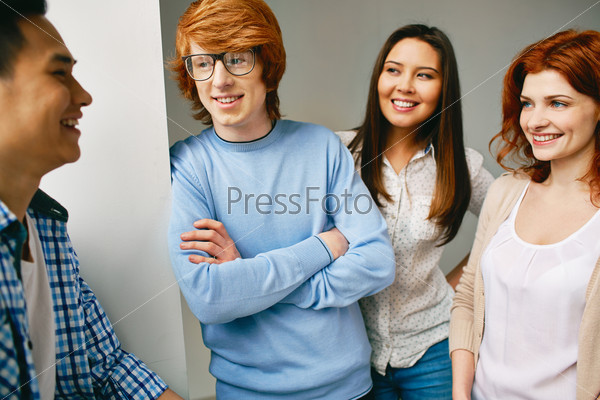 Company of smart groupmates talking in college, stock photo