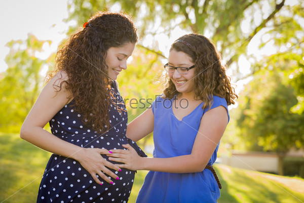 Hispanic Daughter Feels Baby Kick in Pregnant Mother\'s Tummy Outdoors At the Park.