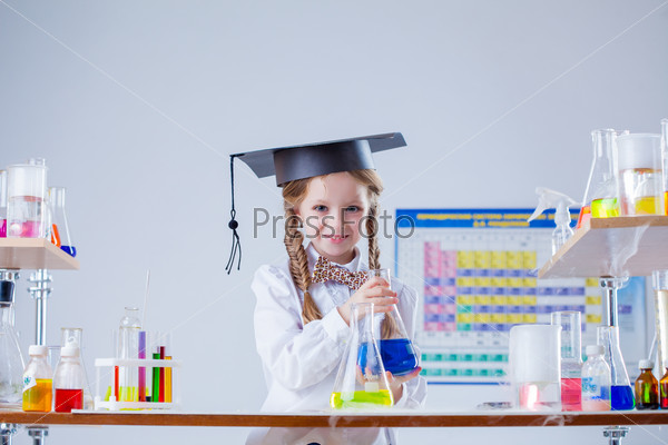 Smiling little girl posing in graduate hat at lab