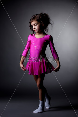 Adorable little gymnast posing in pink dress