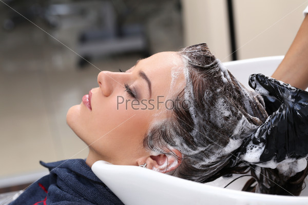 Hairdresser salon. Woman during hair wash