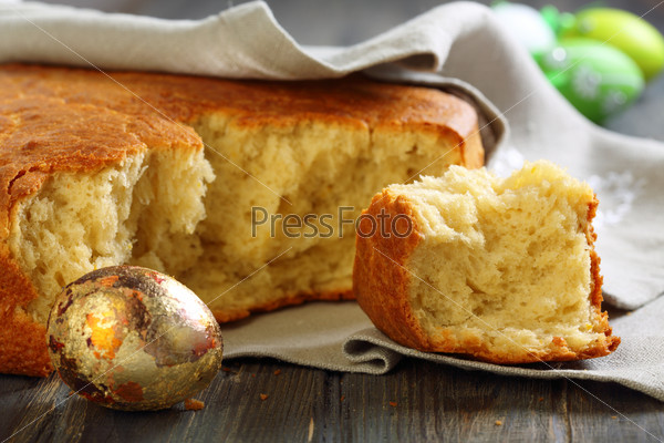 Italian Easter bread and painted eggs on a wooden table, stock photo