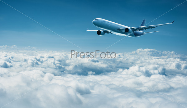 Passenger jet plane flies above the clouds - international travel with modern airlines