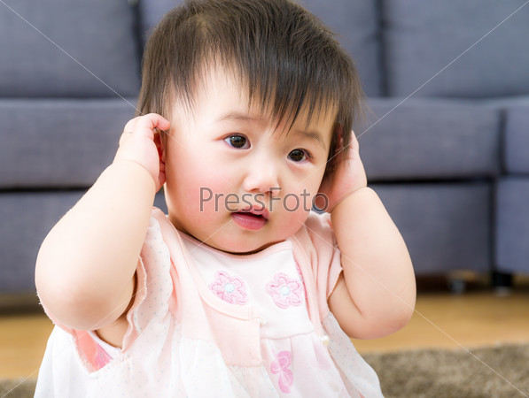 Little girl using hand to cover ear