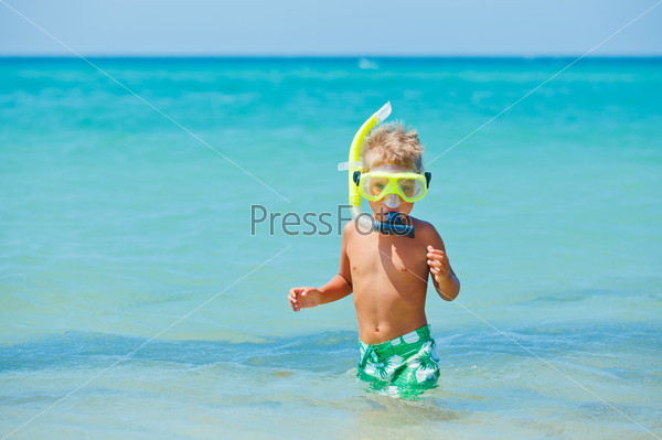 Summer vacation - Portrait of happy boy in face masks and snorkels, sea in background.