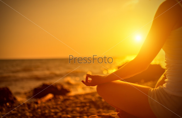 Hand of woman meditating in a yoga on beach