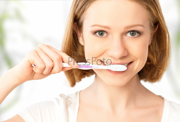 Happy woman brushing her teeth with a toothbrush