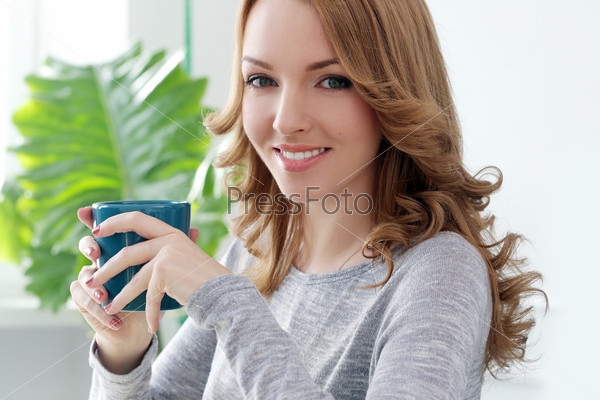 Lifestyle. Cute girl with tea cup at home