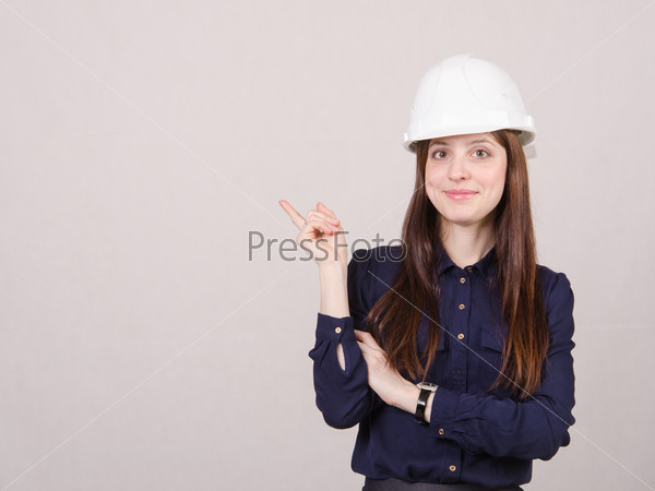 Woman engineer in helmet points finger to right
