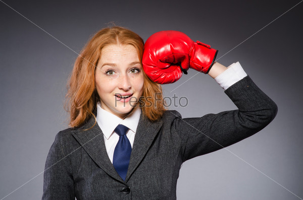 Женщина в боксерских перчатках в темной комнате