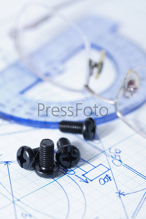 Industry concept. Set of black bolts and screw-nuts near spectacles on graph paper with chart